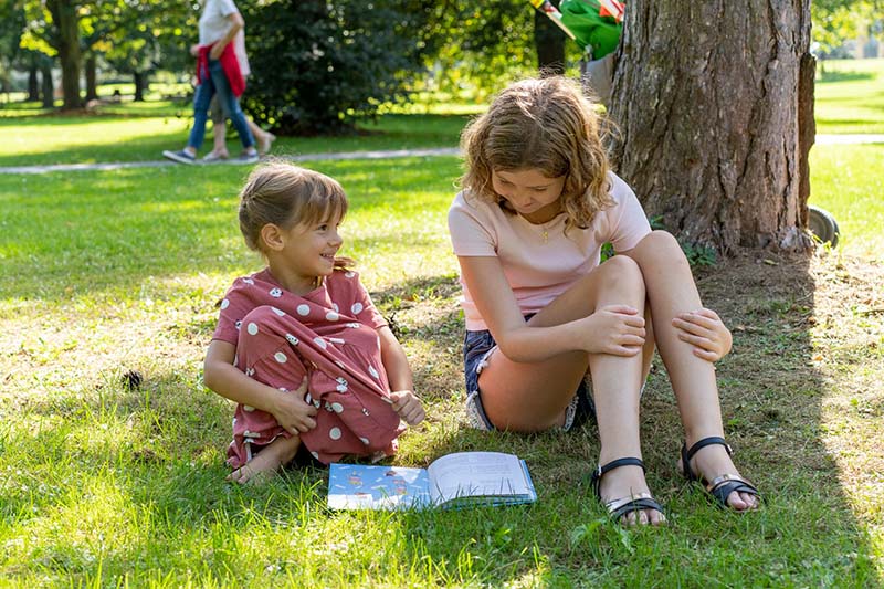 Kinder am Buch-Lesen im Park